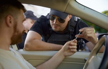 Police officer checking driving license of man driver
